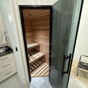 sauna room with a glass door and wooden floor